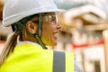 Smiling female construction worker in protective helmet standing against on construction background Royalty Free Stock Photo