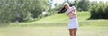 Professional female golf player hit ball with golf club on field Royalty Free Stock Photo