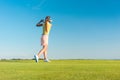 Professional female golf player smiling while swinging a driver Royalty Free Stock Photo