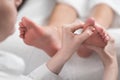 Professional female masseur giving reflexology massage to woman foot