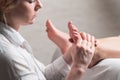 Professional female masseur giving reflexology massage to woman foot Royalty Free Stock Photo