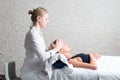 Professional female masseur giving relaxing massage treatment to young female client. Hands of masseuse on forehead of Royalty Free Stock Photo