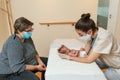 Professional female physiotherapist performing parietal work and lambdoid suture on a newborn.