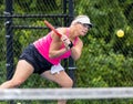 Professional female pickelball player returns a two handed backhand