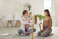 Professional female psychologist during therapy session disclosing teenage girl using jenga game.