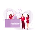 Professional female receptionist serving a pair of guests at the reception desk. Hotel Receptionist concept. Royalty Free Stock Photo