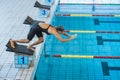 Female swimmer jumping into a pool from the starting block Royalty Free Stock Photo