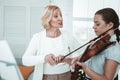 Professional female teacher teaching how to play the violin