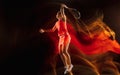 Professional female tennis player isolated on black studio background in mixed light