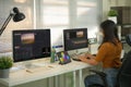 Professional female video editor editing video on his personal computer with two displays in home office studio Royalty Free Stock Photo
