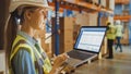 Professional Female Worker Wearing Hard Hat Holds Laptop Computer with Screen Showing Inventory Ch Royalty Free Stock Photo