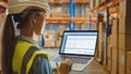 Professional Female Worker Wearing Hard Hat Holds Laptop Computer with Screen Showing Inventory Ch Royalty Free Stock Photo