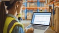 Professional Female Worker Wearing Hard Hat Holds Laptop Computer with Screen Showing Inventory Ch Royalty Free Stock Photo