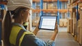 Professional Female Worker Wearing Hard Hat Uses Digital Tablet Computer with Screen Showing Inven Royalty Free Stock Photo