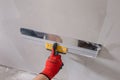 A professional finisher painter levels the walls with putty with a wide spatula Royalty Free Stock Photo