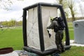 A professional firefighter in a black special fireproof suit prepares to assemble a white oxygen tent to rescue people at a chemic