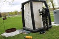 A professional firefighter in a black special fireproof suit prepares to assemble a white oxygen tent to rescue people at a chemic