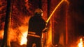 Professional Firefighter Quickly Extinguishing a Forest Fire with the Help of a Fire Hose. Fireman