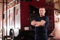 Professional fireman portrait. Firefighter wearing uniform of shirt and trousers. Fire truck in the background