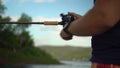A professional fisherman catches a fish by spinning. Hands and fishing rod close-up. A man stands in a boat and sways on Royalty Free Stock Photo