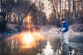 Professional fishing. Fisherman in professional wear standing in river.