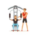 Professional fitness coach and man flexing muscles on trainer gym machine, people exercising under control of personal Royalty Free Stock Photo