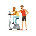 Professional fitness coach and man working out on exercise bike, people exercising under control of personal trainer