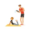 Professional fitness coach with training plan and young woman doing fitness exercises on a mat, people exercising under Royalty Free Stock Photo