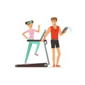 Professional fitness coach and young woman running on thread mill, people exercising under control of personal trainer