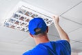 Professional fixing fluorescent light grille panel in office building& x27;s suspended ceiling. Royalty Free Stock Photo