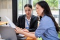 A focused Asian businesswoman is examining a business financial data report with her colleague Royalty Free Stock Photo