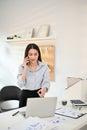 Professional and focused young Asian businesswoman talking on the phone with her client Royalty Free Stock Photo