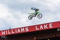 Professional freestyle motocross team member performs stunt high above audience Royalty Free Stock Photo