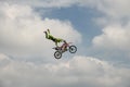 Professional Freestyle rider carries out a trick with the motorcycle on background of the blue cloud sky. Extreme sport. German-St Royalty Free Stock Photo