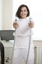 Professional Funny Female Doctor Posing in Doctor`s Smock While Holding Two Intence Pulse Light Apparatus in Laser Rejuvelation Royalty Free Stock Photo