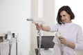 Professional Funny Female Doctor Posing in Doctor`s Smock While Holding Two Intence Pulse Light Apparatus in Laser Rejuvelation Royalty Free Stock Photo