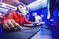 Professional gamer controls computer mouse online game in neon color blur background, soft focus Royalty Free Stock Photo