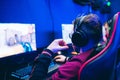 Professional gamer playing online games tournaments pc computer with headphones, Blurred red and blue background