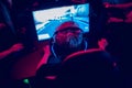 Professional gamer playing online games tournaments pc computer with headphones, Blurred red and blue background