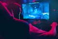 Professional gamer playing online games tournaments pc computer with headphones, Blurred red and blue background