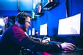 Professional gamer playing tournaments online video games computer with headphones, red and blue