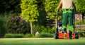 Professional Gardener Mowing the Lawn Back View