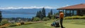 Professional gardener mowing the lush green lawn on a bright and sunny summer day back view shot