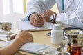 Professional general practitioner doctor man uniform with stethoscope while appointment talking patient with pen writing Royalty Free Stock Photo