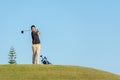 Professional golfer asian man approach on the tee off for swing and hitting golf ball and looking fairway in course. Hobby in holi Royalty Free Stock Photo