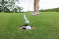 professional golfer asian woman sporty putting golf ball into hole beautifully at on the green golf, double exposure shot Royalty Free Stock Photo