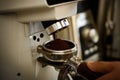 Professional grinding mechanism. Barista grind coffee beans using coffee machine. Coffee grinder grinding roasted beans