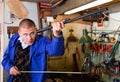 Gun repairman cleaning shotgun barrel before assembly in workshop