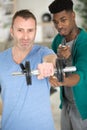professional gym trainer motivating client to lift dumbbell