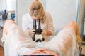 Professional gynecologist examining her female patient on a gynecological chair